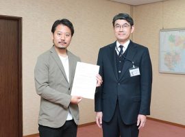 果実酒製造免許を取得した山田貢さん（左）。免許の交付式が行われた川崎西税務署にて木立直文署長（左）と。