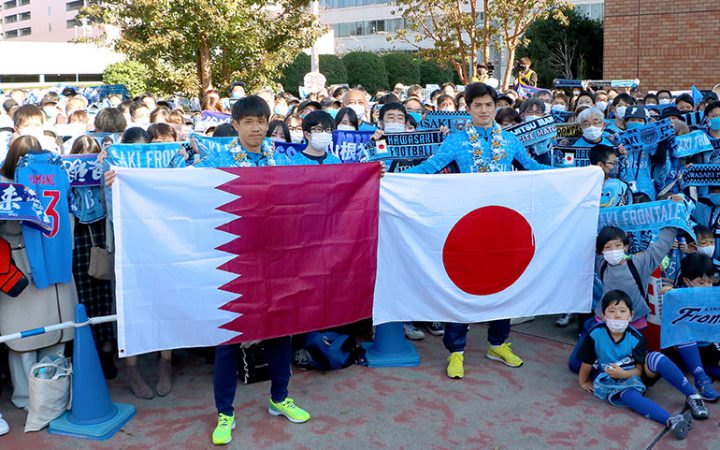 カタールと日本の国旗を手に、サポーターと記念撮影（麻生区役所前広場にて）