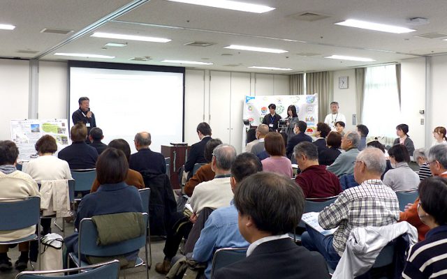 多くの参加者が集まった合同活動報告会。はじめに挨拶をする佐藤直樹多摩区長